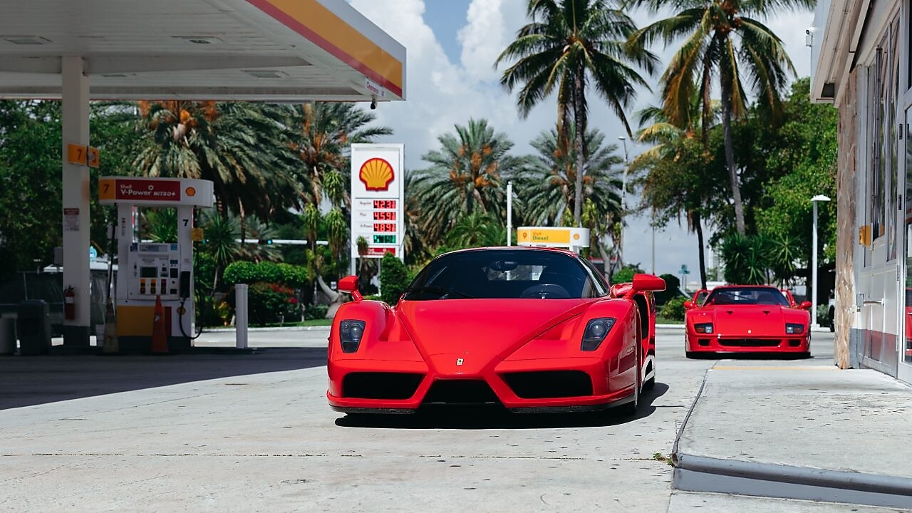 Un coche rojo de Ferrari estacionado en una estación de servicio de Shell