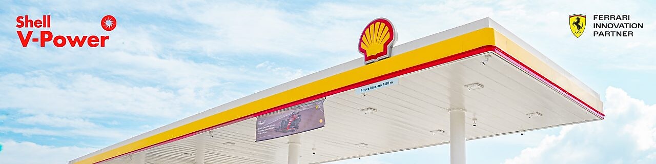 Coche rojo estacionado em estación de servicio de Shell a la noche